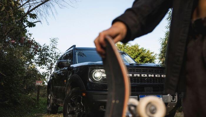 Skate de Yndiara Asp e SUV Ford Bronco Sport ao fundo