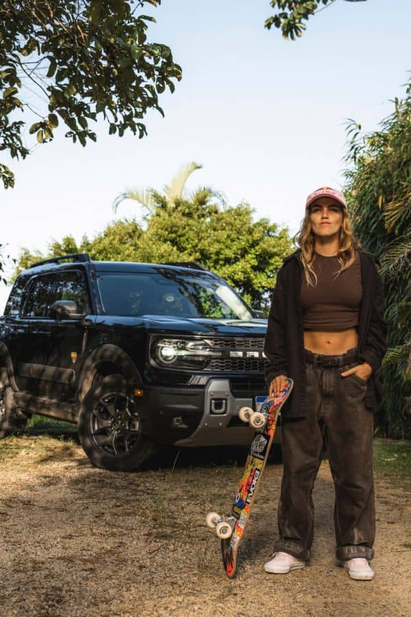 Yndiara Asp posando para foto em frente a um SUV Ford Bronco Sport