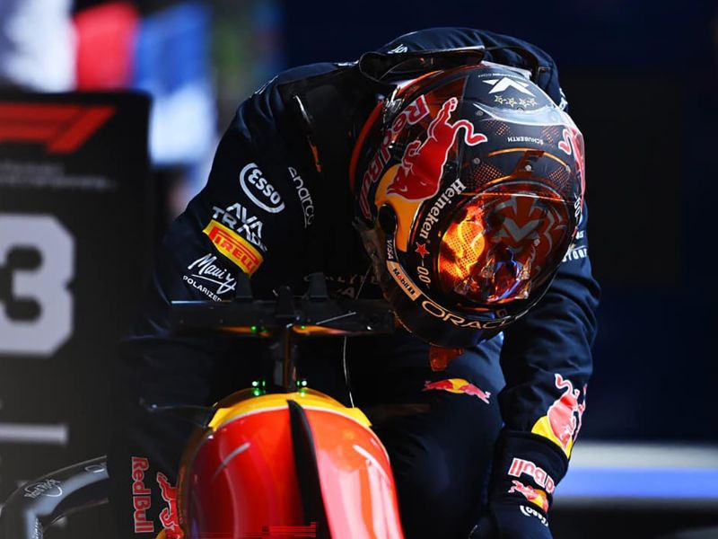 Max Verstappen ao lado de carro de Fórmula 1