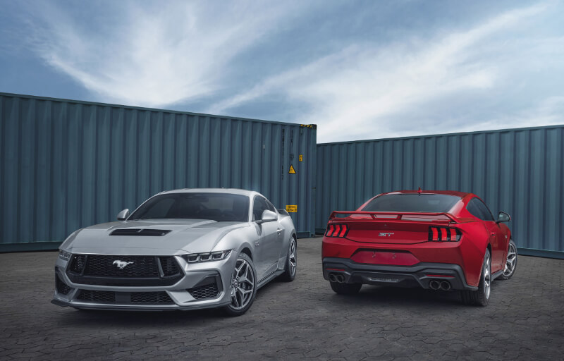 Visão frontal do novo Ford Mustang GT Performance cinza e traseira do Ford Mustang GT Performance Vermelho