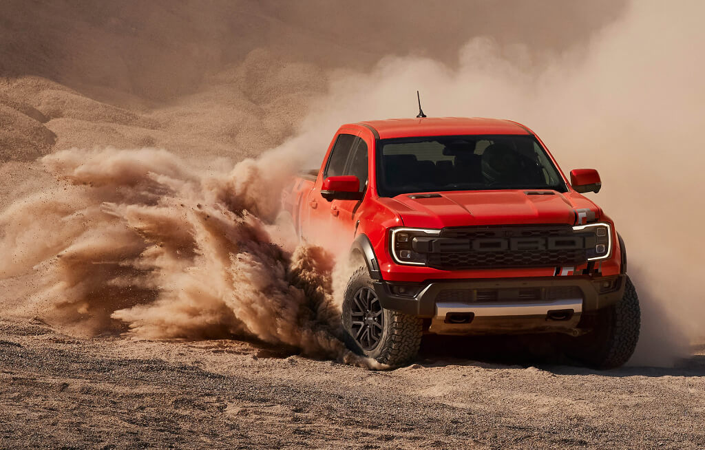 Ford Ranger Raptor Laranja em ambiente off-road com muita poeira