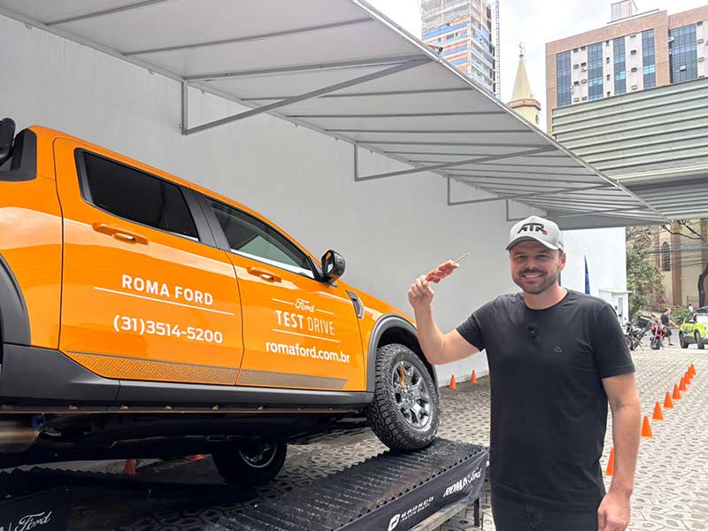 Cliente Participa da Experiência de Test Drive no Dia Raça Forte Cliente ao lado da Ford Ranger laranja durante a experiência de test drive no evento Dia Raça Forte da Roma Ford