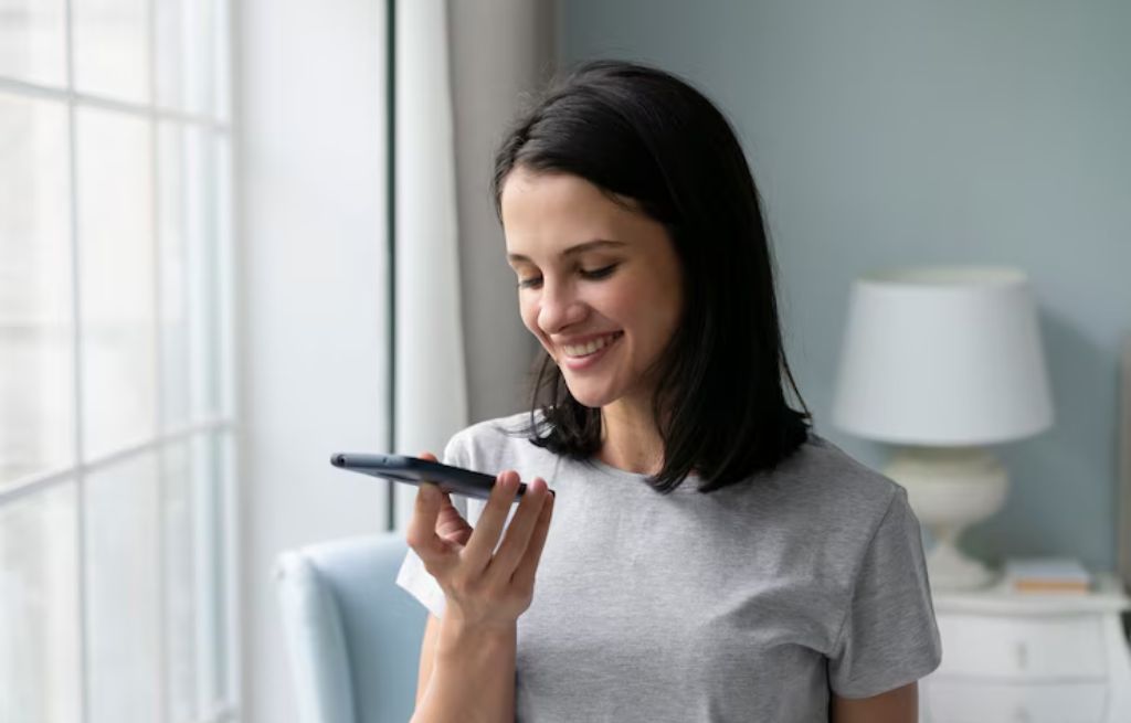 Mulher olhando pro celular e sorrindo