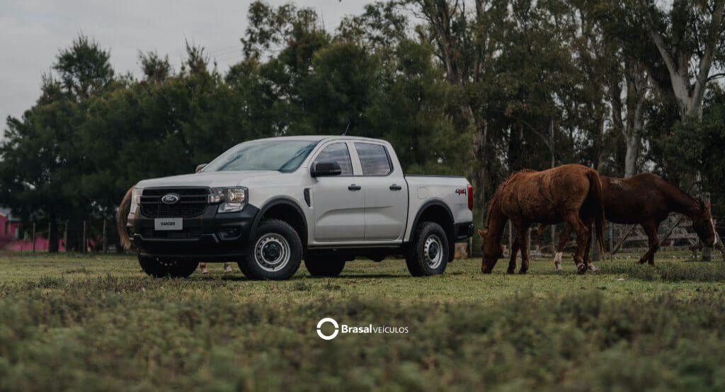Ford Ranger XLS branca em ambiente rural próxima a cavalos