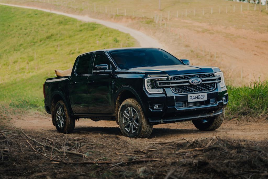 Ford Ranger XLS na cor preta em uma subida de um terreno rural em uma estrada de terra