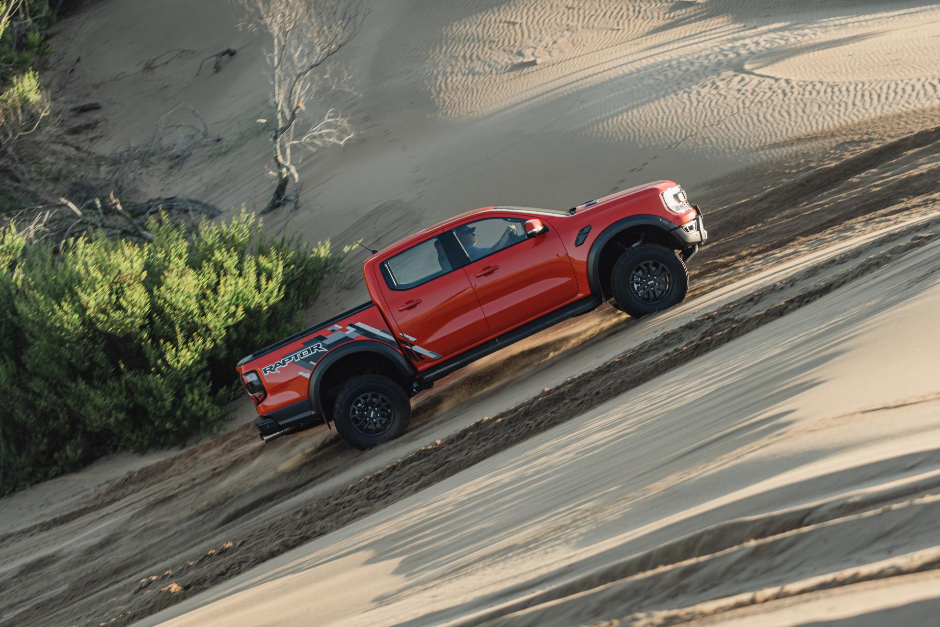 ord Ranger Raptor na cor vermelha em terreno de areia íngreme