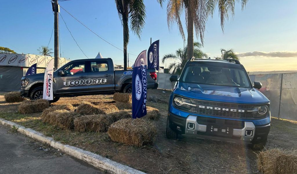 Um carro Ford Bronco azul e um carro Ford F-150 Tremor cinza estacionados