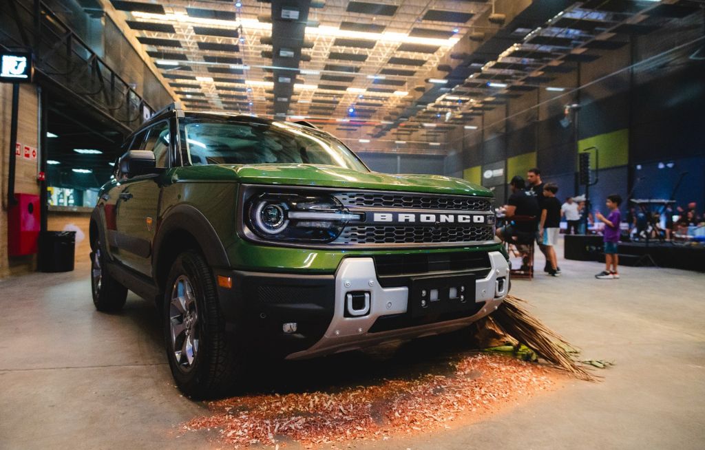 Bronco Sport em destaque Ford Bronco Sport verde exposto em ambiente fechado com decoração temática off-road durante evento da marca