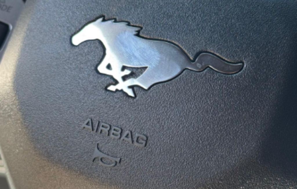 Mustang Manual Logotipo da Mustang no volante, destacando a marca icônica e seu design esportivo