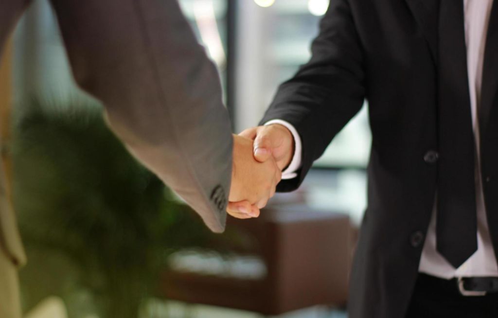 Aperto de mão em ambiente corporativo