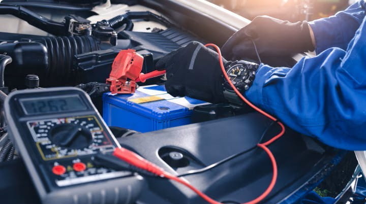 Un mecanico revisando el bateria de un carro