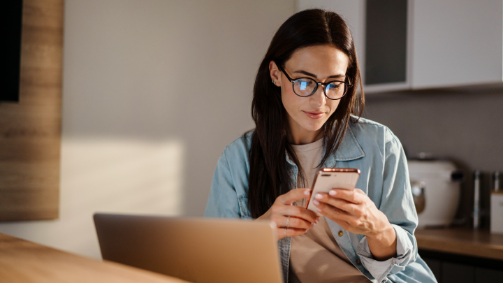 Una mujer sonriendo viendo el celular