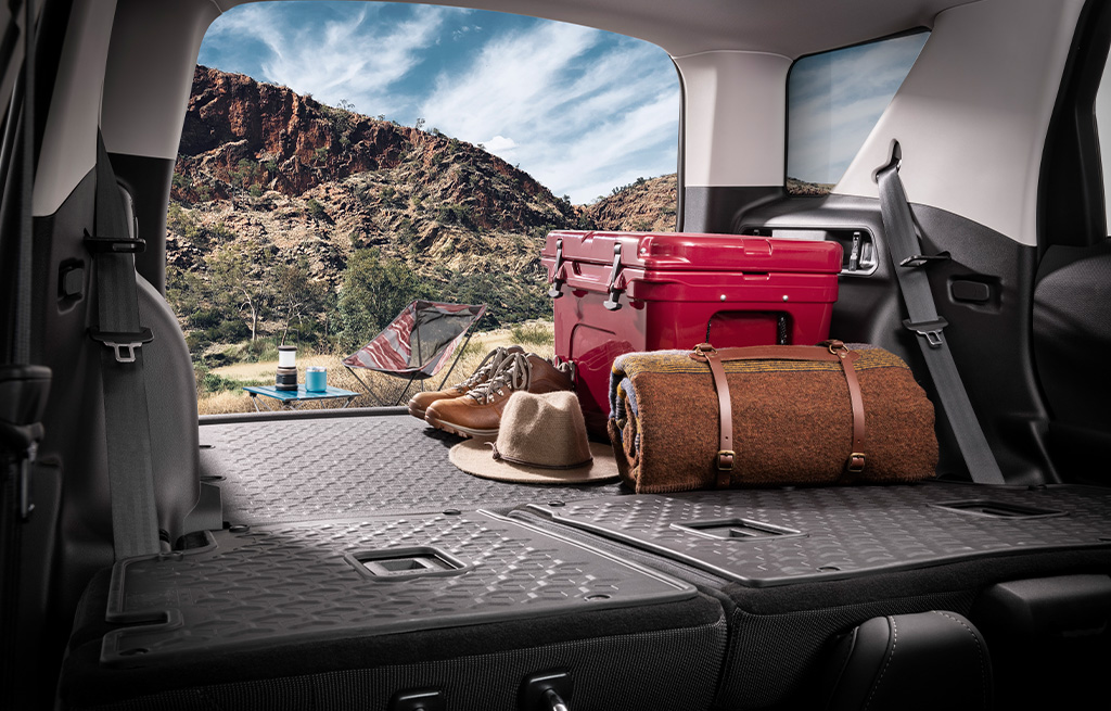 Parte trasera de un vehículo con objetos de acampar en un desierto