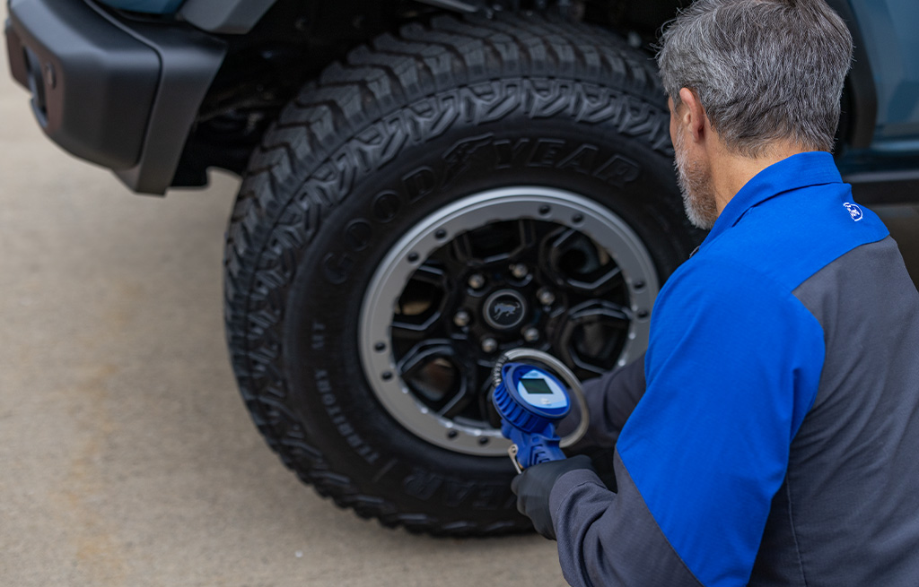 Trabajador de taller calibrando una llanta