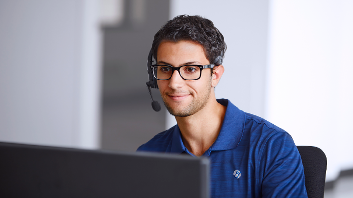 Un hombre sonriendo con unos audifinos y un microfono