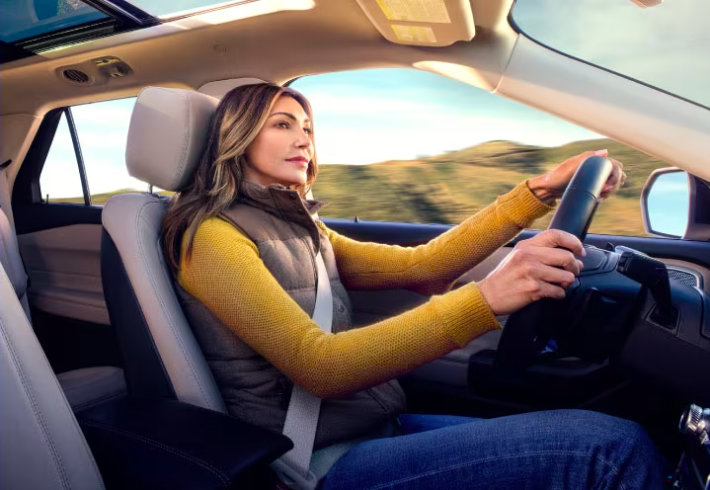 Mujer rubia al volante de un vehículo Ford