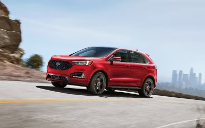 Automóvil rojo Ford en la vía