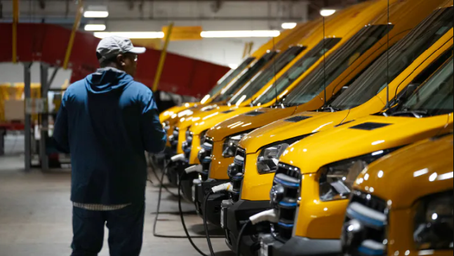Trabajador de servicio revisando varios vehículos Ford amarillos