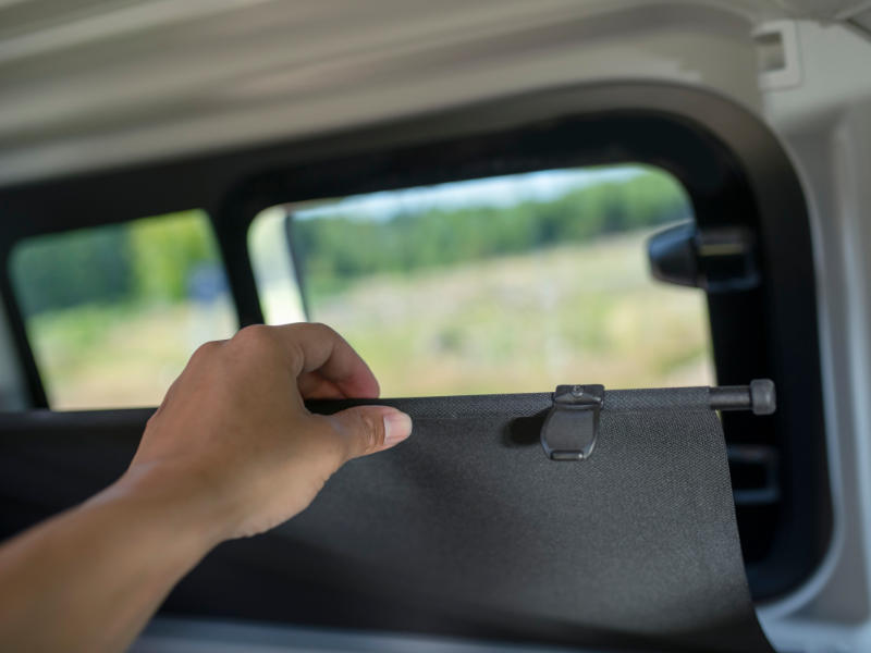 Person vor Fenster des Campers