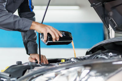 Mechaniker füllt Frostschuzmittel auf