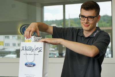 Lehrling im Verkauf verpackt Ware