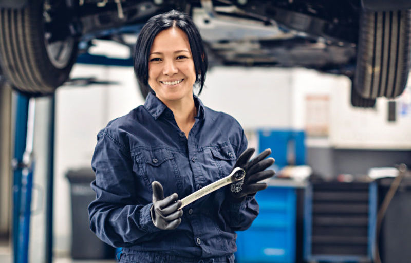 Ford Service Mechanikerin steht in Ford Werkstatt