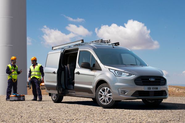 GZwei Bauarbeiter neben einen silbergrauen Ford Tranist Connect