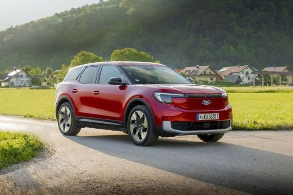 Ford Explorer Roter Ford Explorer parkt auf Landtrasse vor kleinem Dorf