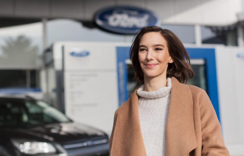 Lächelnde Frau verlässt Ford Garage