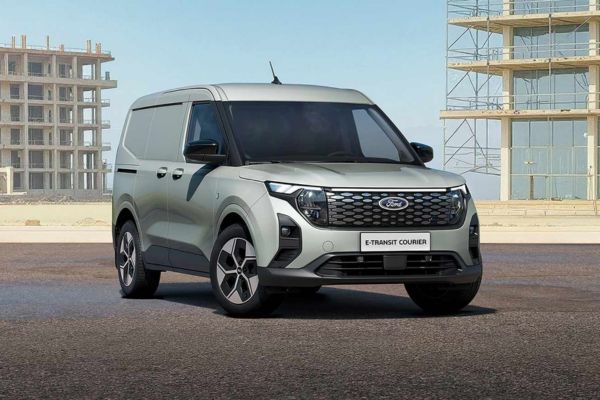 Un Ford E-Transit Courier gris stationné sur une route.