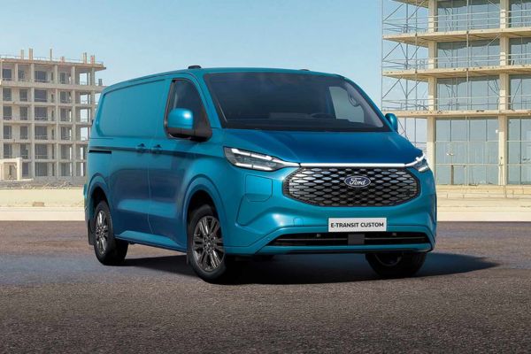 Un Ford E-Transit Custom bleu stationné sur une route.