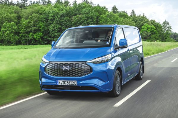 E-Transit Custom in blaue unterwegs auf grüner Landstrasse