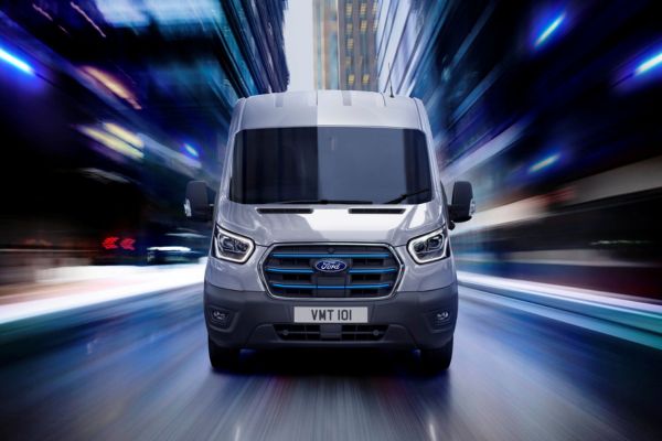 Der Ford E-Transit in Frontansicht mit Wolkenkraztern im Hintergrund