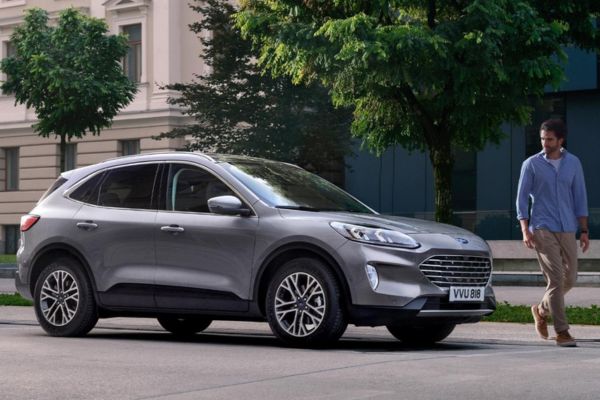 Mann geht entlang Strasse vor Ford Kuga