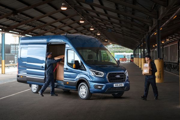 Zwei Personen tragen Kartons in Ford Transit