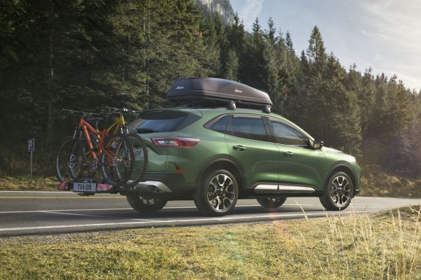 Grüner Ford Kuga mit Zubehör fährt entlang Landstrasse