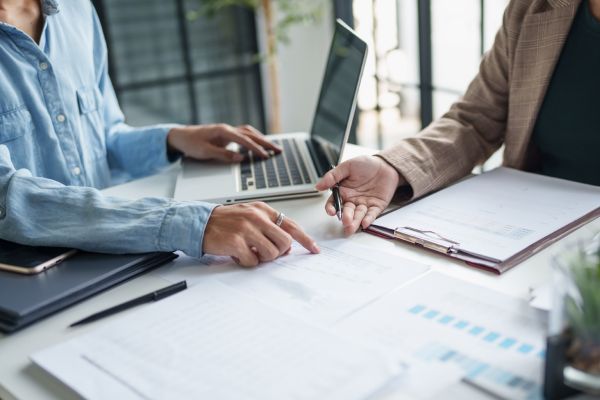 Leasing Zwei Personen sitzen an Tisch und sehen sich Finanzberichte an