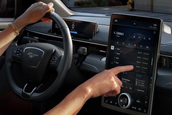 Une personne utilise l'écran tactile pendant que le véhicule se gare.