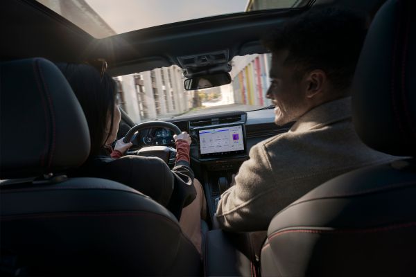 Deux personnes sont assises dans le véhicule et l'écran affiche les données du trajet.