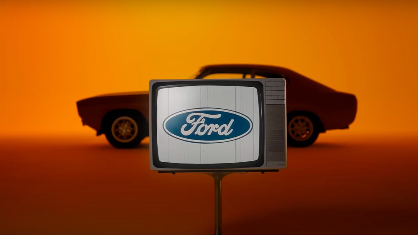 Vintage Ford Capri auf orangem Hintergund mit Ford-Logo