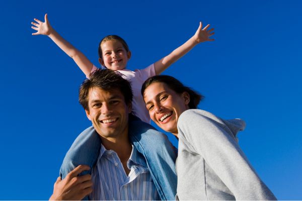 Lächelnde Familie vor blauem Himmel