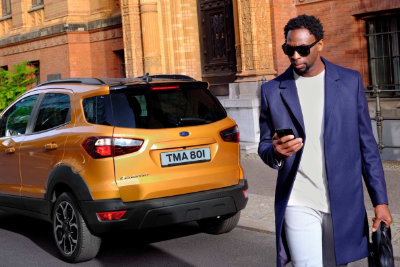 Un homme avec une serviette regarde son téléphone portable