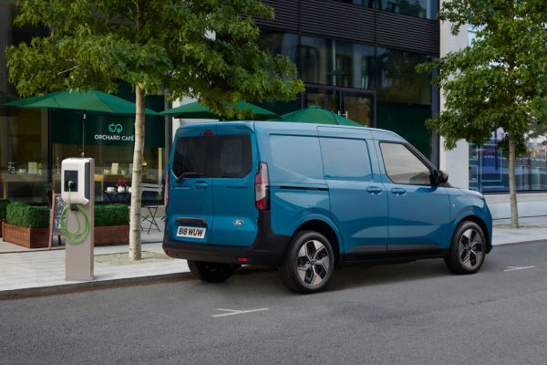 Ford E-Transit Courier La Ford E-Transit Courier est garée à côté d'une borne de recharge dans une rue en ville