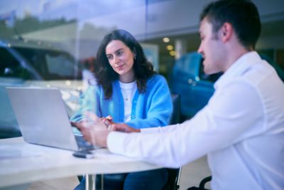 Une cliente se fait conseiller par un vendeur dans le showroom