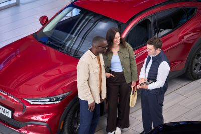 Un employé du service clientèle avec une cliente et un client dans le showroom