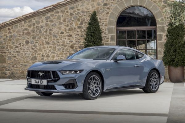 Ford Mustang GT vue de profil garée devant un bâtiment avec un mur en pierre