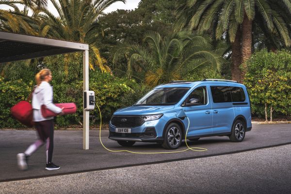 Ford Tourneo Connect est garée devant des palmiers et est en cours de recharge