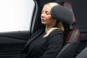 Kvinde benytter sove-hovedstøtte i bil