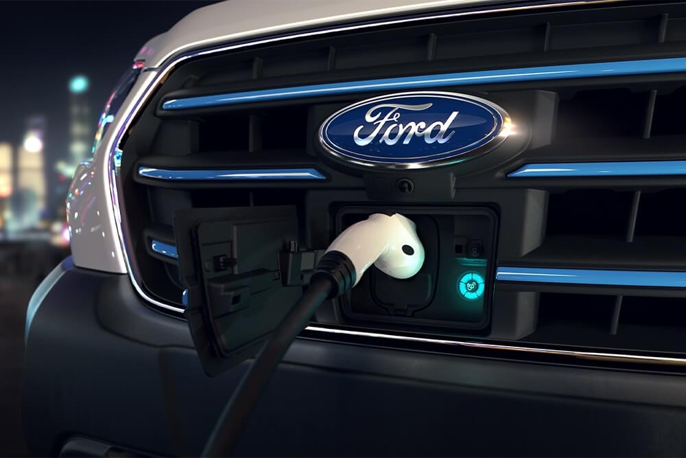 Gros plan d'une borne de recharge pour Ford E-Transit et du badge Ford ovale bleu