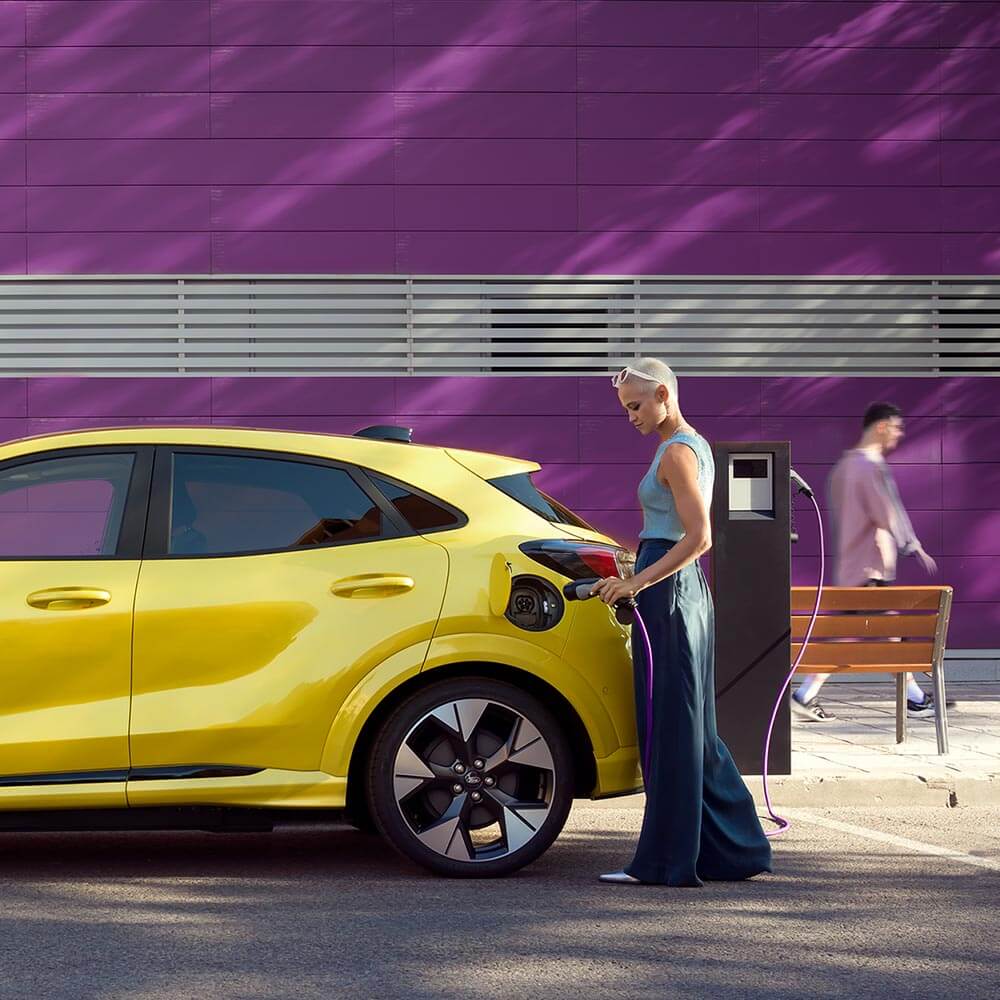 Conductrice mettant en charge une Ford Puma jaune